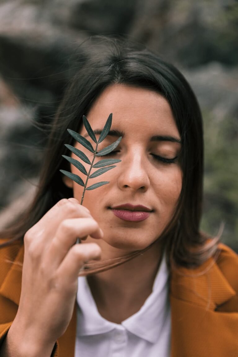 mujer respirando en la naturaleza con una hoja en la mano
